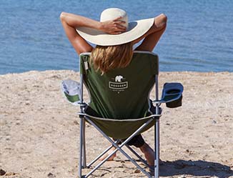 Person sitting on a sunny beach in a chair with a logo on the back