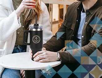 People sitting at a table holding custom Stanley dupe.