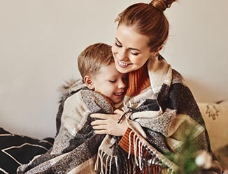 Happy mom and son wrapped in a custom blanket.