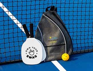 Customized Pickle Ball set and imprinted bag sitting on a court.