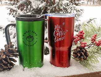 Red and green travel imprinted tumblers in snow with holiday decor